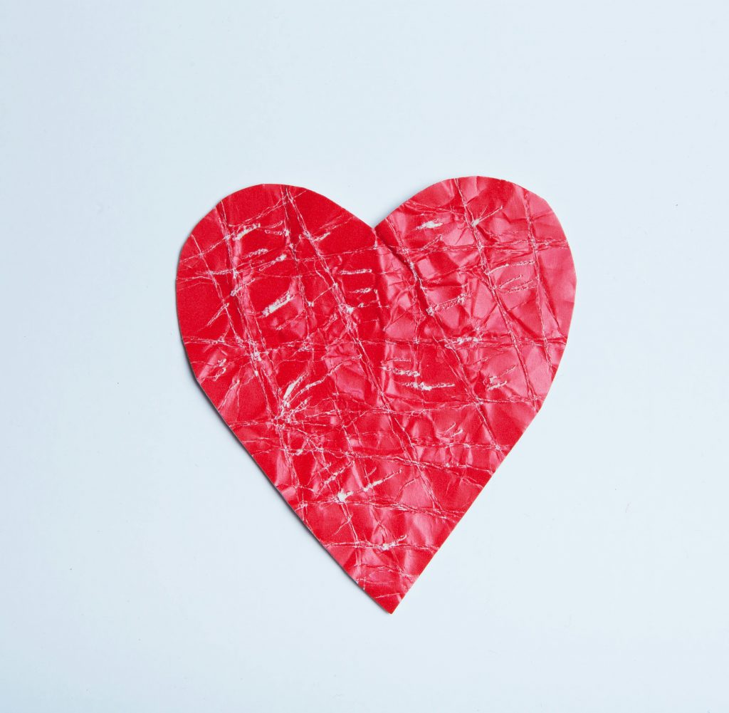 Corazón de papel arrugado simbolizando el impacto del estilo de apego en las relaciones