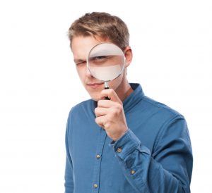 Persona con lupa, analizando la validez de la hipnosis para lograr autoconocimiento