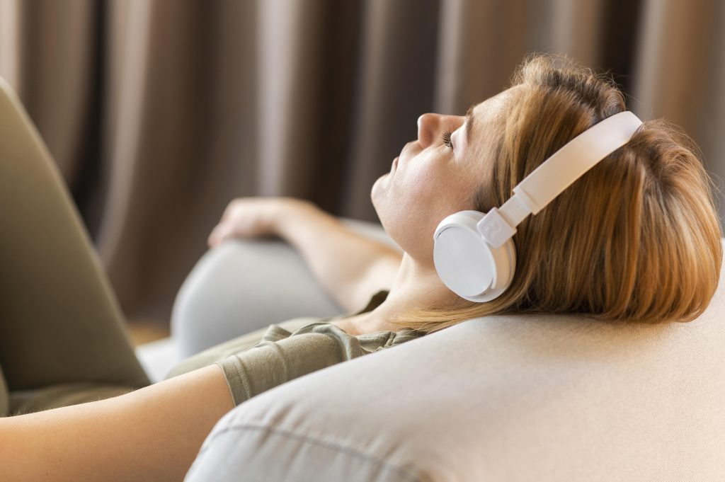 Mujer tumbada con auriculares escuchando una píldora hipnótica para relajación